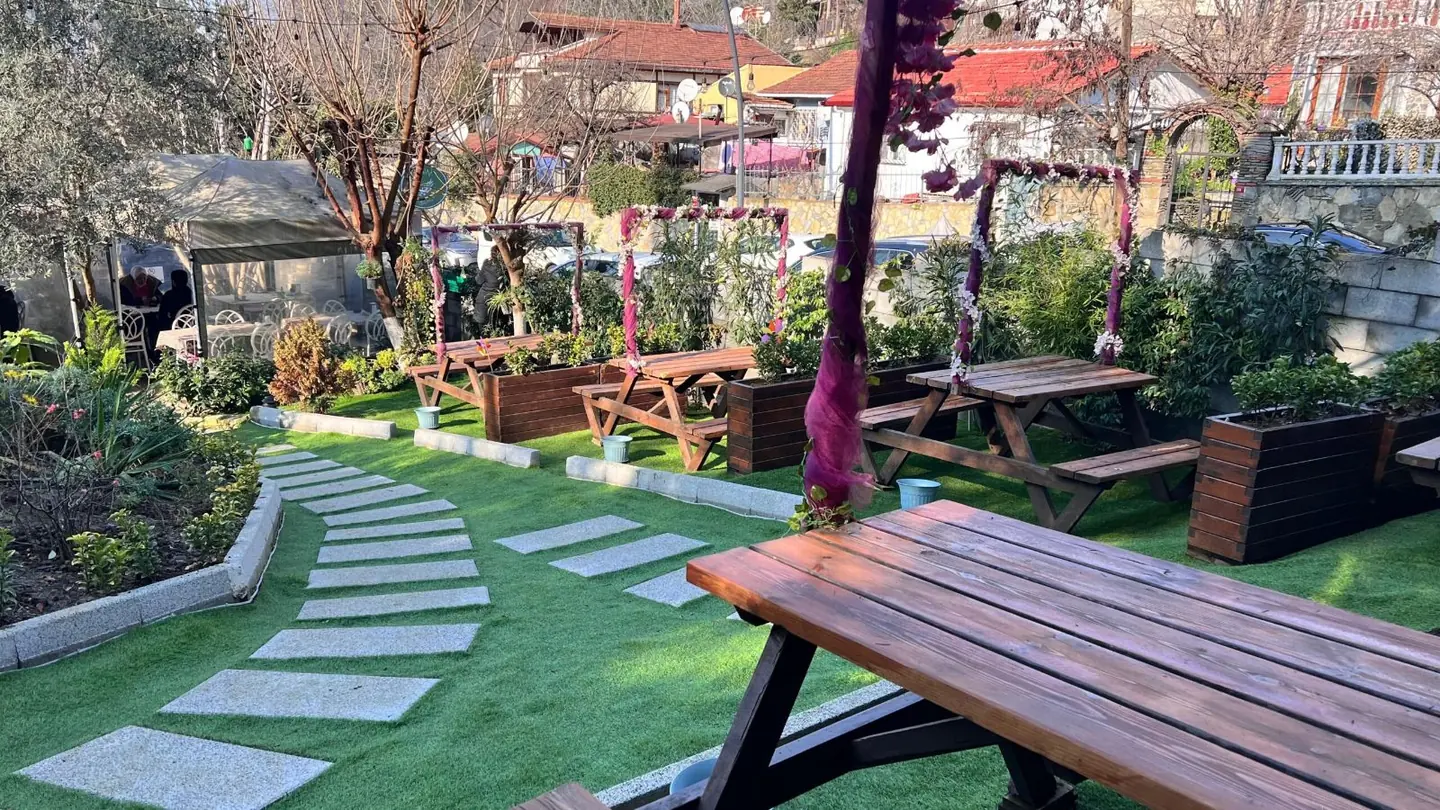Taş yol ve ahşap masalar