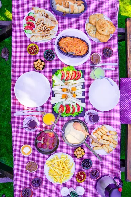 Pembe kareli örtü üzerinde kahvaltı sofrası
